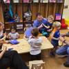 Kiddie Academy owners Ricardo Mogollon and Jerry Nesbit, both in blue, spend some quality time with a few of their child clients and staff members within their newly opened business in Henderson.