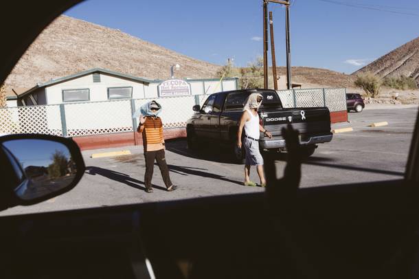 A couple of men leave the bath house and wave hello at Tecopa Hot Springs Campground on October 1, 2015.