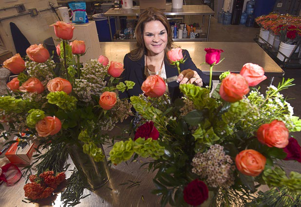 Dana Beatty, director of floral and horticulture at the Venetian/Palazzo, displays an arrangement of Venetian and Palazzo roses at the Palazzo floral department Wednesday, Oct. 28, 2015. The Venetian roses are red and the Palazzo roses are peach-colored.