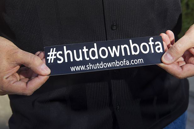 Michael Bondi holds a sticker outside a Bank of America branch in Henderson Monday, Nov. 2, 2015. Bondi has a federal lawsuit pending against Bank of America and Nationstar Mortgage.