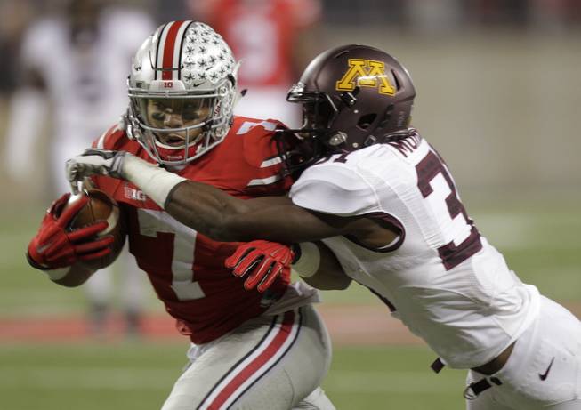 Ohio State running back Jalin Marshall, left, runs with the ball after a catch as Minnesota defensive back Eric Murray makes the tackle.