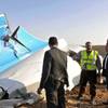 In this Saturday, Oct. 31, 2015, file photo, Egyptian Prime Minister Sherif Ismail, right, looks at the remains of a crashed Russian passenger jet in Hassana, Egypt. 