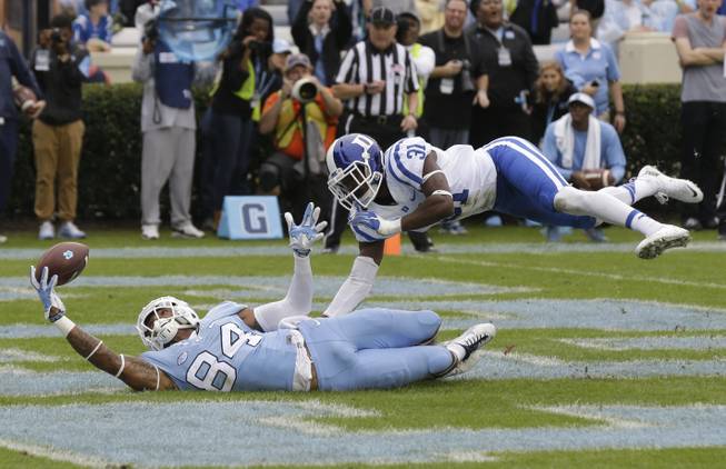 North Carolina's Bug Howard (84) reaches for a pass as Duke's Breon Borders (31) defends during the first half of an NCAA college football game in Chapel Hill, N.C., Saturday, Nov. 7, 2015. The pass fell incomplete.