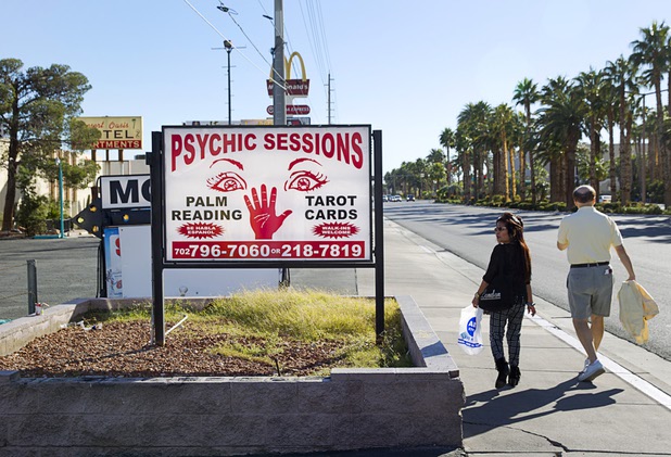 A couple walks by businesses on Las Vegas Boulevard South Monday, Nov. 23, 2015.