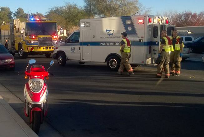A firetruck and ambulance are shown after the rider of a motor scooter, foreground, collided with a vehicle Monday, Nov. 30, 2015, at the intersection of South Duneville Street and West Reno Avenue, near Jydstrup Elementary School.