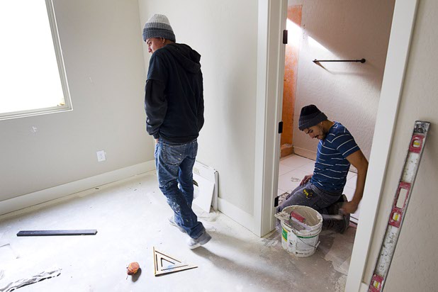 Christian Zelaya, left, and Dennis Rivas set tile in a model home at The Estates at Rhodes Ranch, a Century Communities development, Thursday, Dec. 3, 2015.