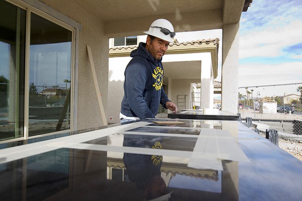 Delfino Barajas prepares to cut a hole for a bathroom sink in a granite countertop during construction of model homes at The Estates at Rhodes Ranch, a Century Communities development, Thursday, Dec. 3, 2015.