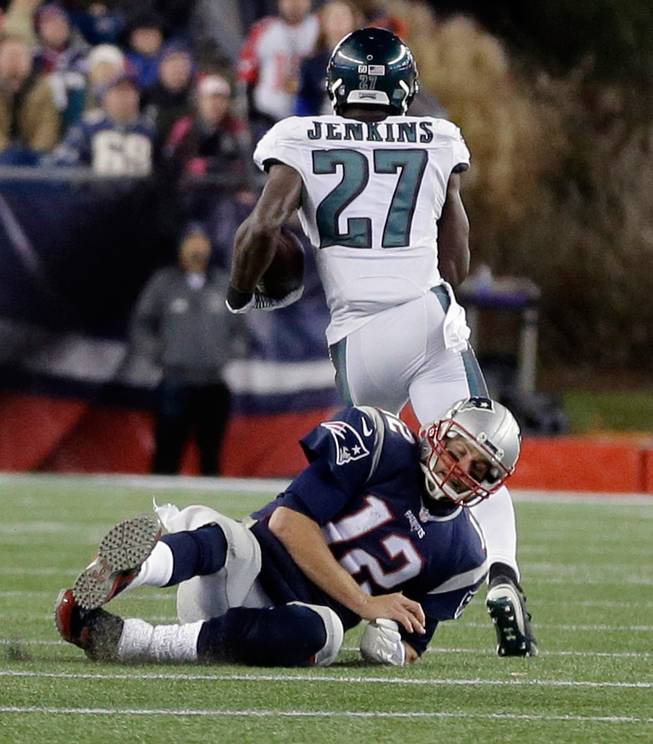Philadelphia Eagles safety Malcolm Jenkins runs past a tackle attempt by New England Patriots quarterback Tom Brady (12) with a 100-yard interception return for a touchdown during the second half of an NFL football game, Sunday, Dec. 6, 2015, in Foxborough, Mass. (AP Photo/Steven Senne)