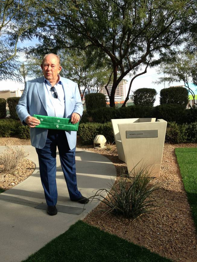 Robin Leach stands near the bench dedicated to him at the Cleveland Clinic Lou Ruvo Center for Brain Health on Sunday, Dec. 6, 2015, in downtown Las Vegas.