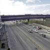 In this Wednesday, Nov. 25, 2015 photo taken in Tijuana, Mexico, vehicles pass under a walking bridge that connects the new Cross Border Xpress air terminal in San Diego, right, to the Tijuana International Airport, left. The new terminal is scheduled to begin operations on Wednesday, Dec. 9, 2015. 