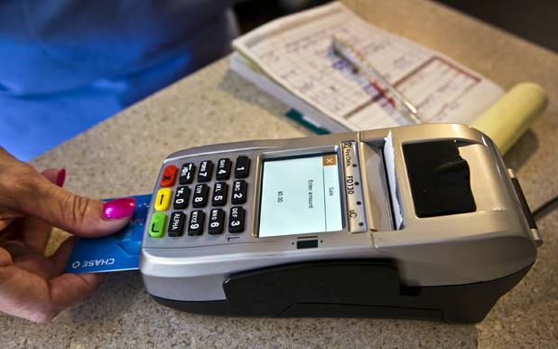 Michele Walker of Imaginations Unlimited in Henderson uses the EMV system in her business where chips placed on credit cards on Tuesday, November 17, 2015.