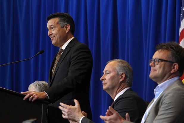 Nevada Governor Brian Sandoval speaks during a news conference at the Sawyer State Building in Las Vegas Thursday, Dec. 10, 2015. Sandoval was joined by Dag Reckhorn, right, from electric-car startup Faraday Future who discussed plans to open its $1 billion factory in the city of North Las Vegas. Steve Hill, director of the Governors Office of Economic Development applauds at center.
