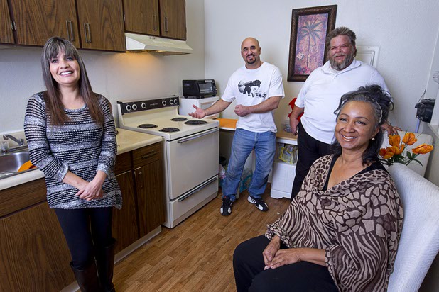 Natalie Perry, right, poses with her neighbors in her apartment Sunday Dec. 13, 2015. Her neighbors came to her rescue during a kitchen fire on Halloween. From left are:  Rocio Mendez, Nick Berbari, and Don Mumma.
