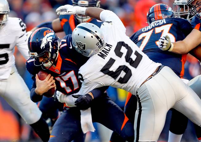 Denver Broncos quarterback Brock Osweiler is sacked by Oakland Raiders defensive end Khalil Mack during the second half Sunday, Dec. 13, 2015, in Denver.