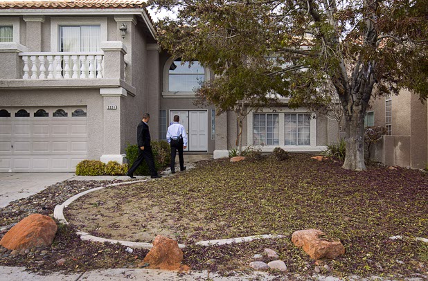 Metro Police officers Jose Martinez, left, and Malcolm Napier check on a home in the northwest part of the valley Dec. 9, 2015.