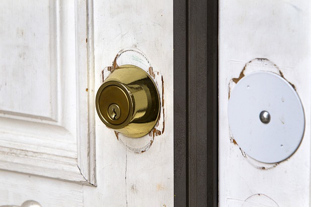 A deadbolt lock is shown on the front door of a house in the northwest part of the valley Dec. 9, 2015. Evidence of a recent lock change may indicate the house is being used by squatters, police say.