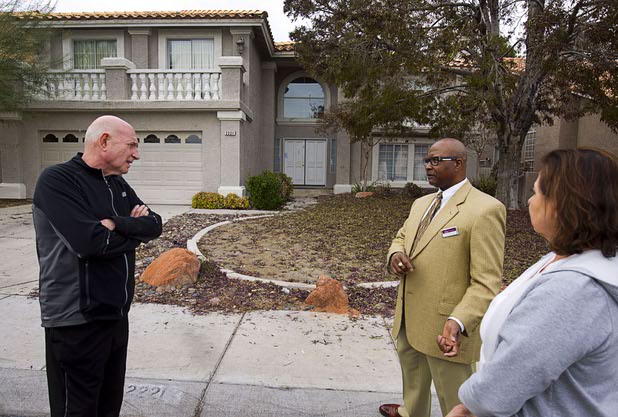 Neighbors Jeff Raithel, left, Flemming Moses, center, and Yvonne Karim talk in front of a house that was occupied by squatters in the northwest part of the valley Dec. 9, 2015. The neighbors said the occupants of a squatter house threw a Halloween party that got out of hand and ended in an early morning shooting.