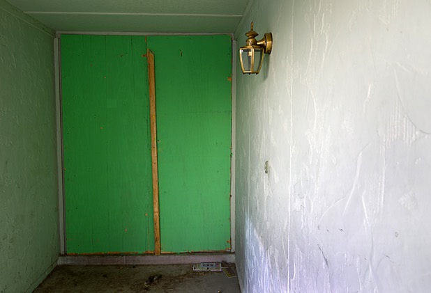 The front door is boarded at a vacant home in the northwest part of the valley Dec. 9, 2015. Police say the home was being used by squatters who were selling drugs from the house.