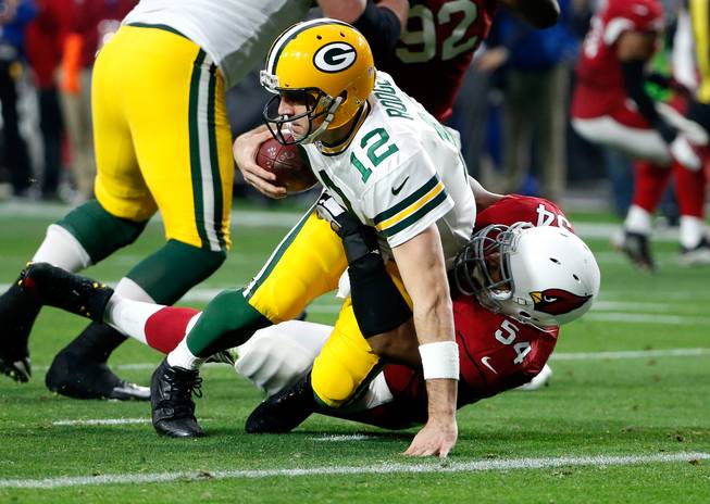 Green Bay Packers quarterback Aaron Rodgers is sacked by Arizona Cardinals inside linebacker Dwight Freeney during the second half of an NFL game Sunday, Dec. 27, 2015, in Glendale, Ariz.