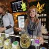 In this Friday, Dec. 18, 2015, photograph, LivWell store manager Carlyssa Scanlon shows off some of the products available in the marijuana line marketed by rapper Snoop Dogg in one of the marijuana chain's outlets south of downtown Denver. LivWell grows the Snoop pot alongside many other strains on its menu. 