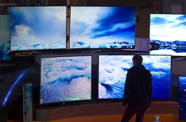 A man sets up a display of televisions in preparation for the 2016 International CES at the Las Vegas Convention Center Sunday, Jan. 3, 2016. The trade show floor opens on Jan. 6.