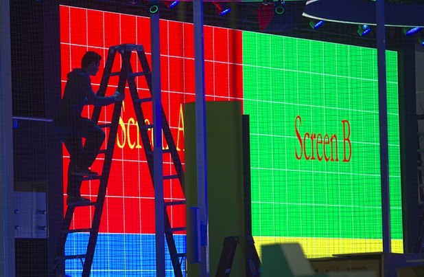 A worker adjusts lights on a drone cage in preparation for the 2016 International CES at the Las Vegas Convention Center Sunday, Jan. 3, 2016. The trade show floor opens on Jan. 6.