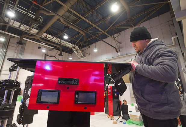 Billy Dominguez sets up a display of automotive electronics in the Boss Audio Systems booth in preparation for the 2016 International CES at the Las Vegas Convention Center Sunday, Jan. 3, 2016. The trade show floor opens on Jan. 6.