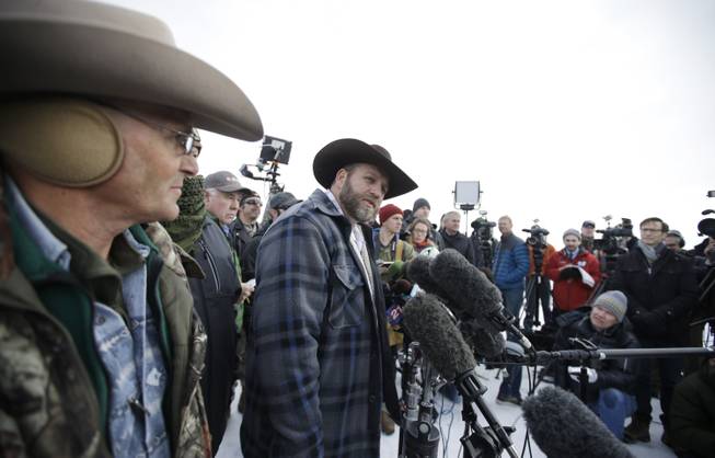 Ammon Bundy, center, one of the sons of Nevada rancher Cliven Bundy, speaks with reporters during a news conference at Malheur National Wildlife Refuge headquarters Monday, Jan. 4, 2016, near Burns, Ore.