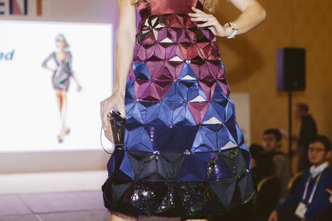 A model walks down the runway at a FashionWare show during CES at the Venetian on Jan. 7, 2016.  She is wearing The Origami Gown which is part of the Gilded Fractals Collection by Make Fashion Designers Kenzie Housego, Stacey Morgan and engineer Sophia Amin. Also featured is a smartwatch by Martian Watches.