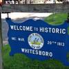 In this photo taken July 16, 2015, a welcome sign on the village green, Whitesboro, N.Y., displays the village seal. Whitesboro will let voters decide whether to keep the longtime village seal that has been called offensive to Native Americans. 