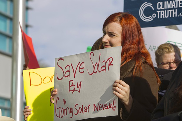 Solar supporter Cristin Barnes holds a sign during a rally in front of Public Utilities Commission offices Wednesday, Jan 13, 2016.