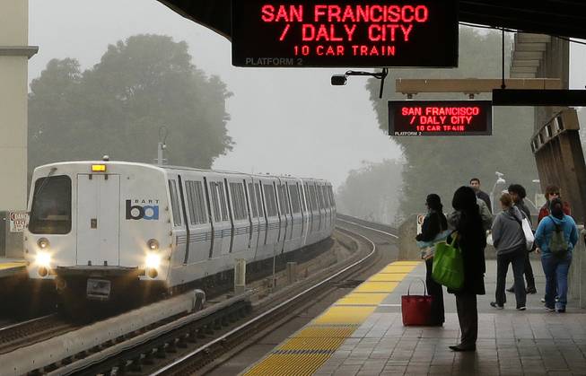Bay Area Rapid Transit passengers wait for a train in ...