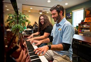 Former homeless student Dessirae Lorena receives a little piano lesson from Executive Director in the music room at the Nevada Partnership for Homeless Youth headquarters on Friday, January 15, 2016.