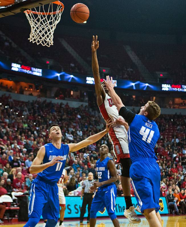 UNLV forward Derrick Jones Jr. (1) knifes in for a basket between Air Force forward Joe Tuss (11) and Air Force center Zach Moer (41) during their game at the Thomas & Mack Center on Saturday, January 16, 2016.