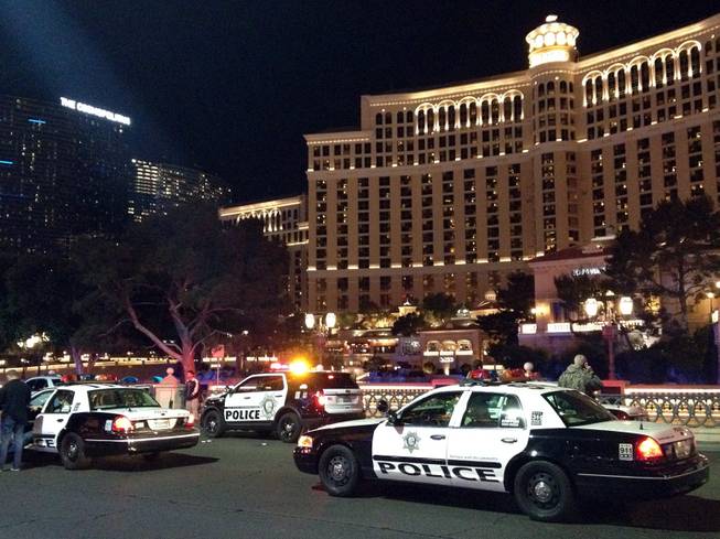Metro Police officers block traffic at Las Vegas Boulevard South, in front of Bellagio, at the scene of an officer-involved shooting Friday, Jan. 22, 2016.