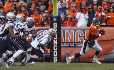 Denver Broncos quarterback Peyton Manning is chased out of the pocket by New England Patriots defenders Sunday, Jan. 24, 2016, in Denver.