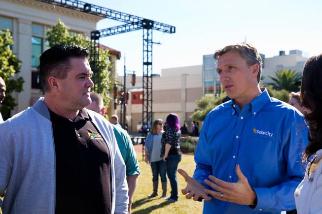 Scott Shaw, of Go Solar, and SolarCity CEO Lyndon Rive converse during a rally for solar energy held at Town Square Las Vegas, Monday Jan. 25, 2016.