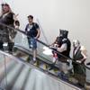 This July 30, 2015, photo shows people dressed as gaming characters as they take the escalator in the convention hall at the Gen Con gaming convention in Indianapolis. Tourism officials say Indiana may have lost as much as $60 million in revenue after a dozen conventions chose cities other than Indianapolis amid the uproar over the state’s controversial religious objections law. 