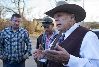 Rancher Cliven Bundy, right, responds to a question from a reporter at his ranch Wednesday, Jan. 27, 2016, near Bunkerville. In the background are family friend Corey Houston, left, and Cliven's son Mel Bundy.