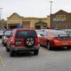 In this photo taken Thursday, Jan. 21, 2016, cars fill the parking lot of a Wal-Mart store in Fairfield, Ala., as it prepared to shut down. Stores slated to shut down Thursday, Jan. 28, 2016, will leave residents in parts of Fairfield, Ala.; Coal Hill, Ark.; and Wichita, Kan., without a supermarket. 