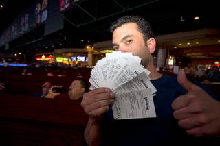 Marc Z (no last name given) of Chicago displays his betting tickets as he watches Super Bowl 50 in the Westgate Super Book Sunday, Feb. 7, 2016.