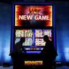 People stand in front of an oversized slot machine at the Aristocrat booth during the Global Gaming Expo on Wednesday, Sept. 30, 2015, in Las Vegas. Massachusetts Gaming Commission members met Thursday, Feb. 18, 2016, to discuss draft regulations for “skill-based” slot machines that incorporate video game and arcade-like elements meant to appeal to millennials who skip over traditional slot machines that they see as old-fashioned.