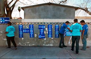 Hillary Clinton campaign volunteers work to post signs across the street from the Democratic Caucus which begins soon at Rancho High School on Saturday, February 20, 2016.