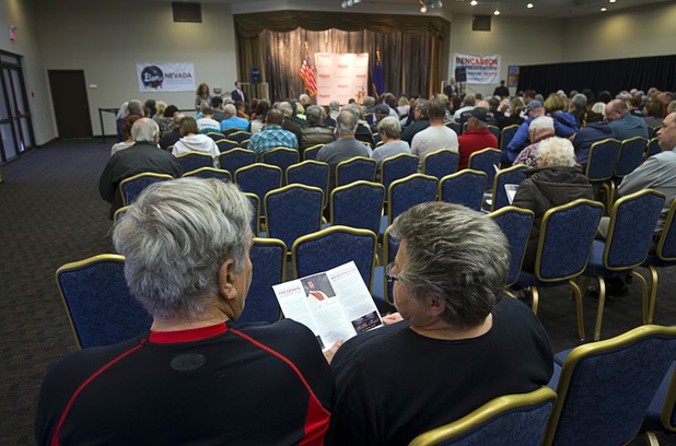 A couple look over a pamphlet on Republican presidential candidate Ben Carson before Carson's campaign stop at the Mountain Shadows Community Center in Summerlin Tuesday, Feb. 23, 2016.