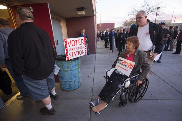 Ben Carson supporters Heidi and Kevin McDonald head into the Western High School GOP caucus site Tuesday, Feb. 23, 2016.