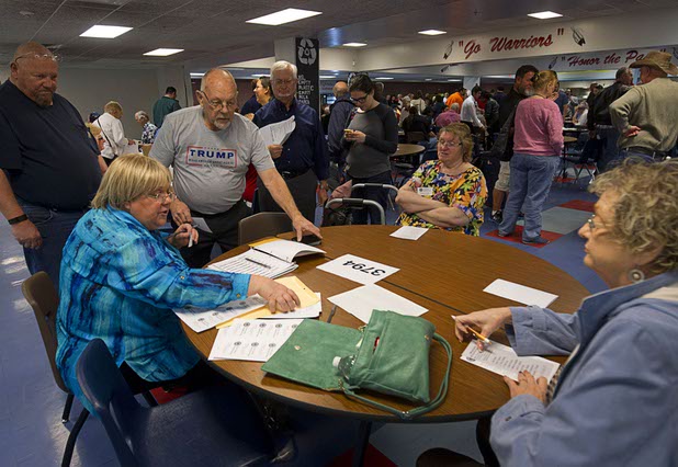 Donald Trump supporter Lafe Brown (wearing Trump T-shirt) casts a ballot at the Western High School Republican caucus site Tuesday, Feb. 23, 2016. 