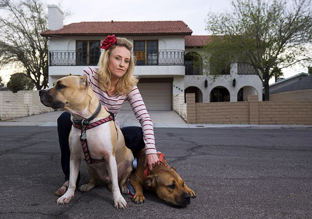 Paige Gordon, along with pit bulls Ziggy, left, and Ava, keep an eye on vacant properties in her neighborhood Sunday, Feb. 28, 2016. STEVE MARCUS