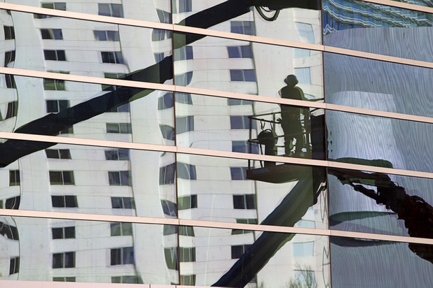 A worker is reflected in the glass of the T-Mobile Arena Tuesday, March 1, 2016. The 20,000-seat arena, a joint venture between AEG and MGM Resorts, is scheduled to host it's first event on April 6.
