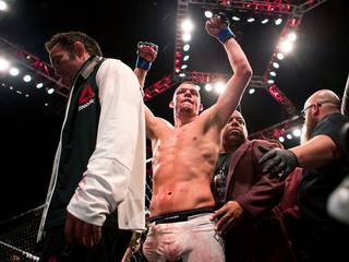 Welterweight Nate Diaz raises his hands in victory while leaving the octagon after beating Conor McGregor during UFC 196 from the MGM Grand Garden Arena on Saturday, March 5, 2016.