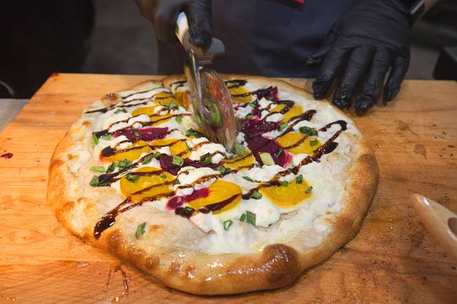 A pizza with a Sprouted White Spring Whole Grain Flour crust is cut at the Ardent Mills booth during the 2016 International Pizza Expo at the Las Vegas Convention Center Tuesday, March 8, 2016. Sprouted whole grain flour is made by intentionally sprouting the whole grains and then milling them.